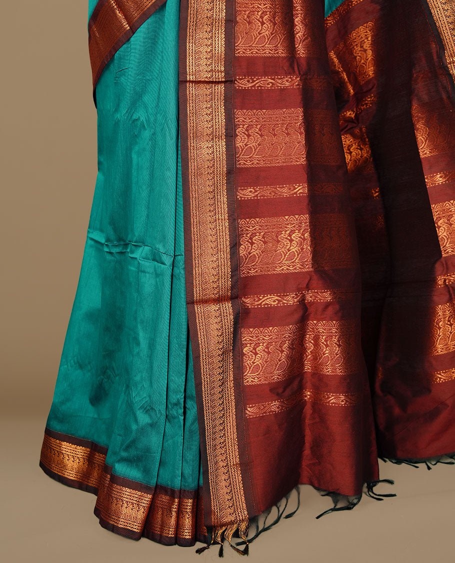 Peacock green colour kalyani cotton saree featuring gold zari motifs on body, complemented by Maroon colour with Antique zari border, paired with matching blouse piece.