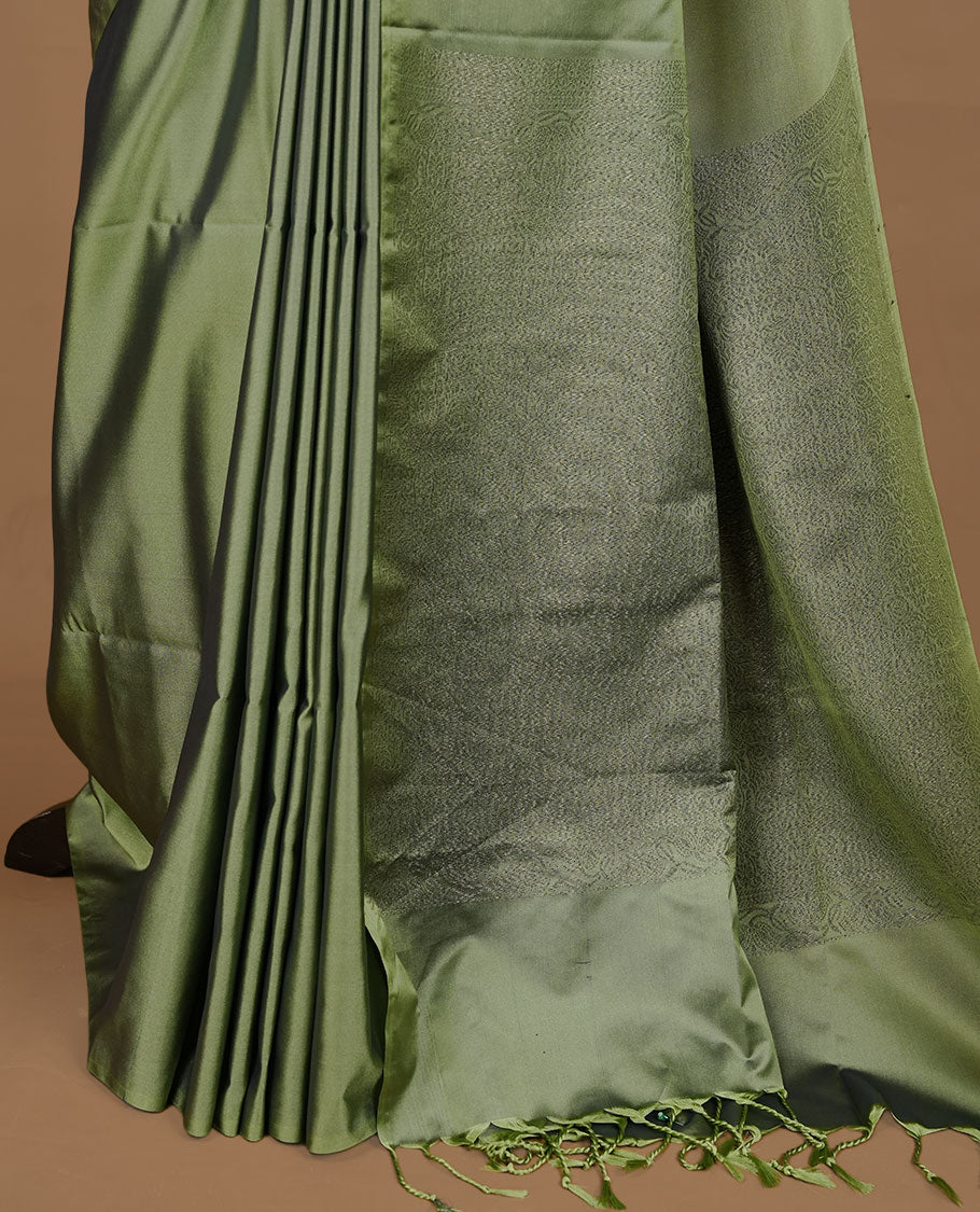 Seafoam green soft silk saree features a sleek borderless design with intricate antique zari motifs, flowing into a seamless self colored pallu and a matching blouse piece.