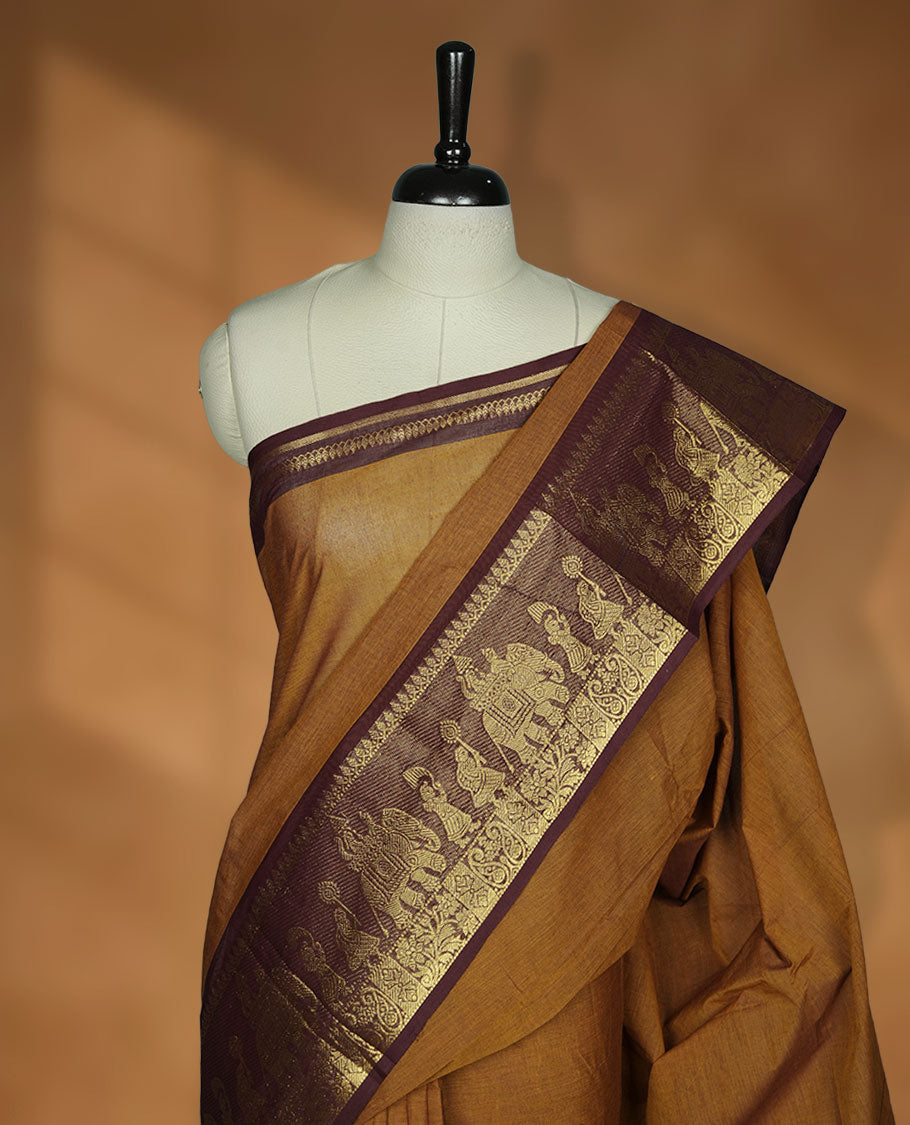 Mustard colour chettinad cotton saree featuring plain body, contrast chocolate brown colour with traditional gold zari border paired with matching blouse.