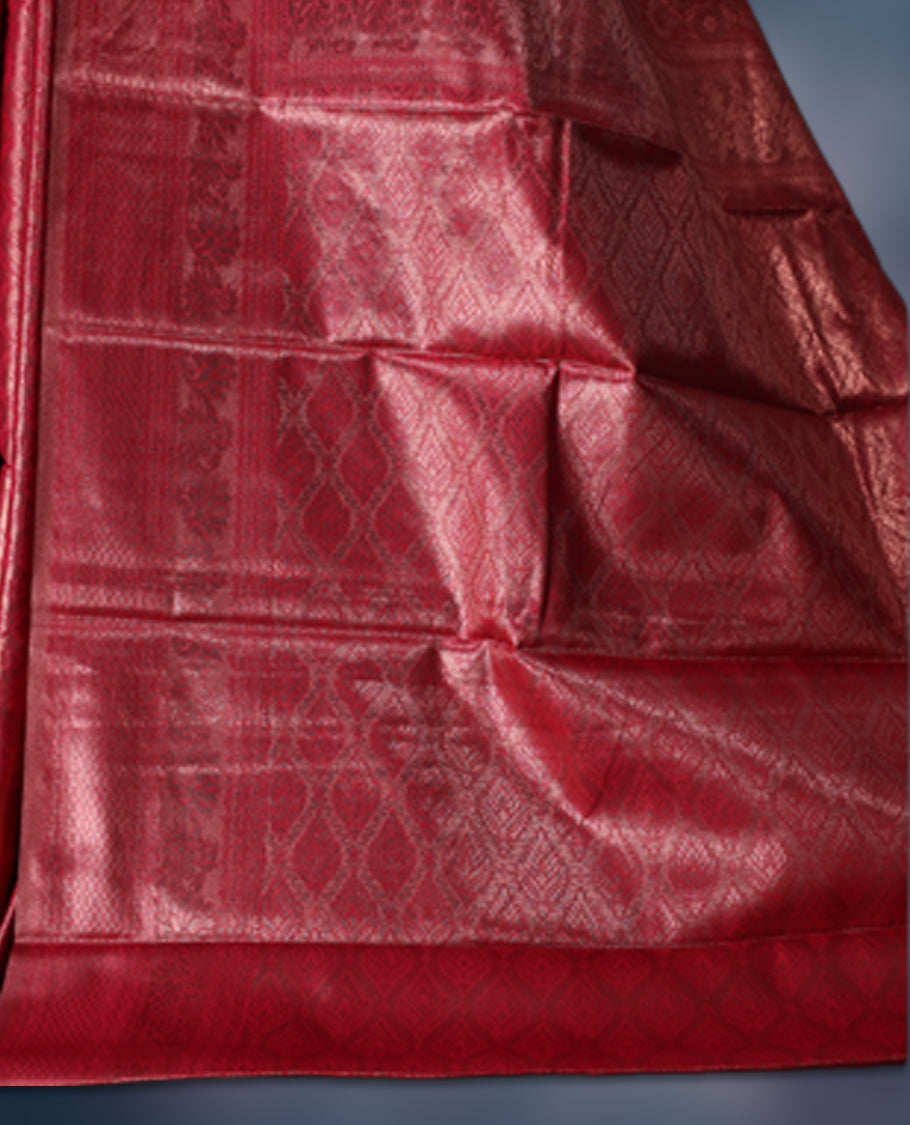Maroon colour semi silk brocade saree featuring intricate self design brocade patterns across the body, complemented by a rich self colour woven border and pallu, paired with a matching blouse.