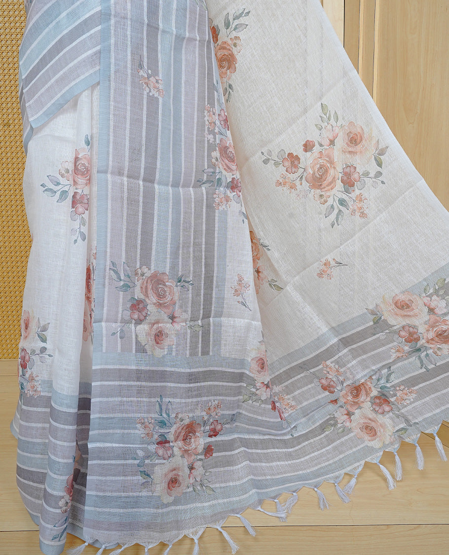 Cream colour semi linen saree featuring Floral printed buttas on body, complemented by contrast Grey colour border, comes with matching blouse piece.