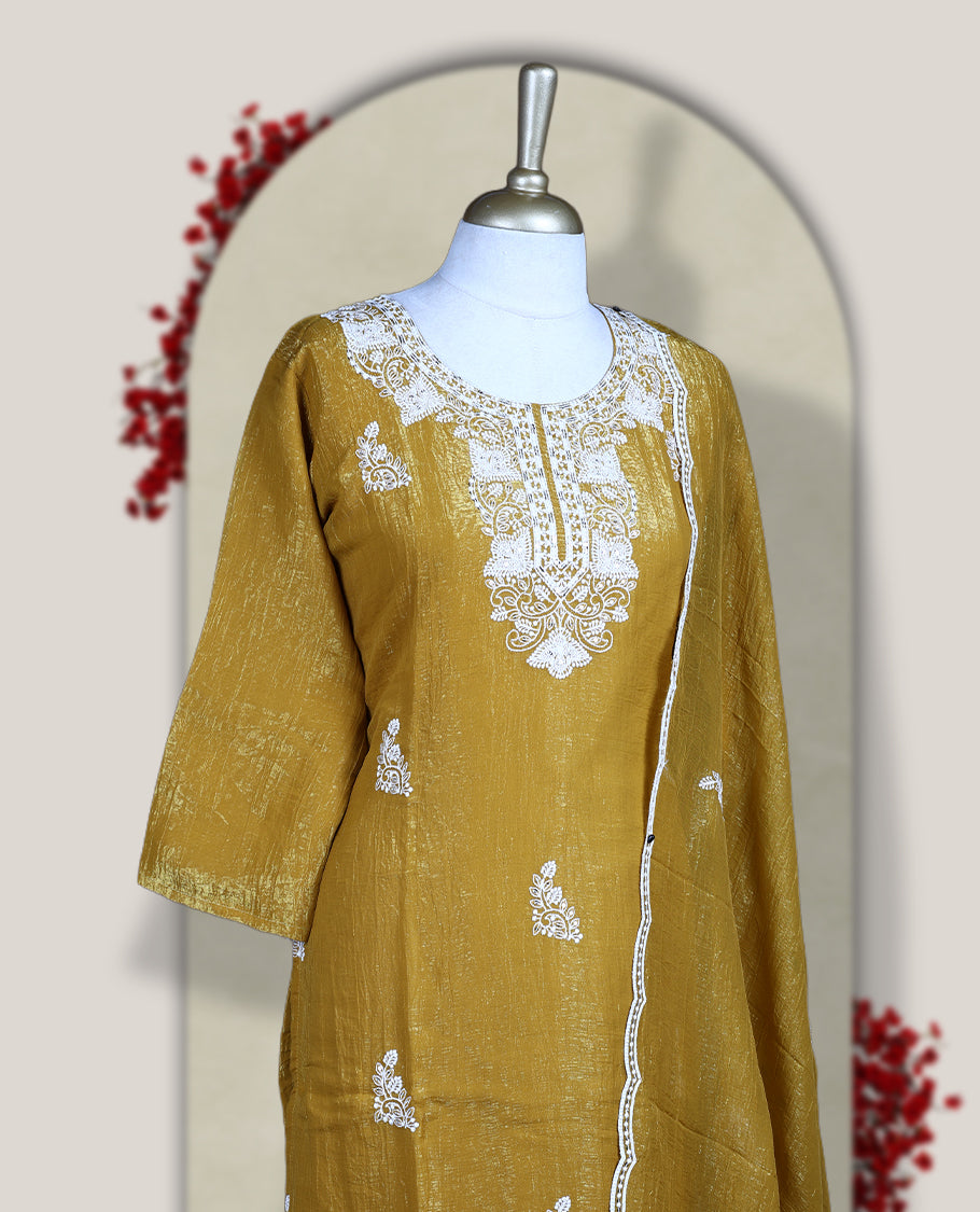 Mustard yellow churidar set featuring elegant white thread embroidery on the neckline, sleeves, and scattered motifs across the body, Paired with a matching embroidered dupatta, this ensemble radiates graceful charm and festive appeal.