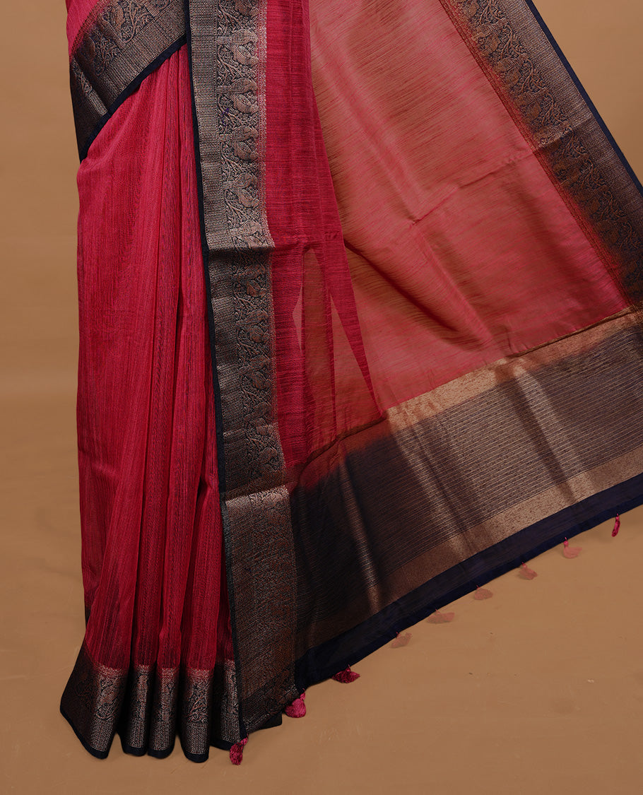 Saffron red colour Semi linen saree featuring Elegant plain body, complemented by contrast Navy Blue colour With Antique zari border, paired with matching blouse piece.