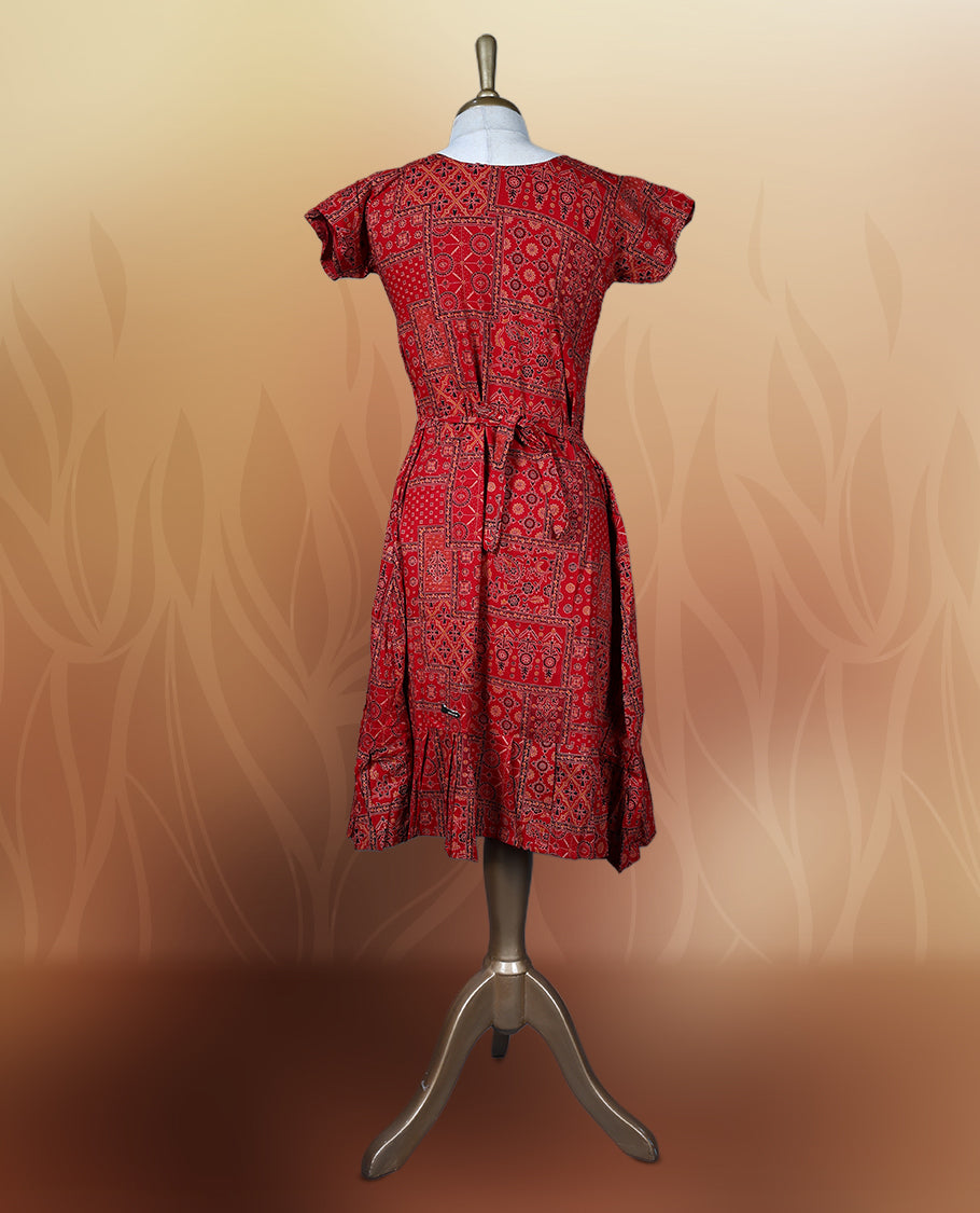 Red colour nightwear with traditional patch style prints in black and white, Features a V neck, puff sleeves, and a ruffled flared hem, A stylish pick for festive occasions, casual wear, or ethnic flair.
