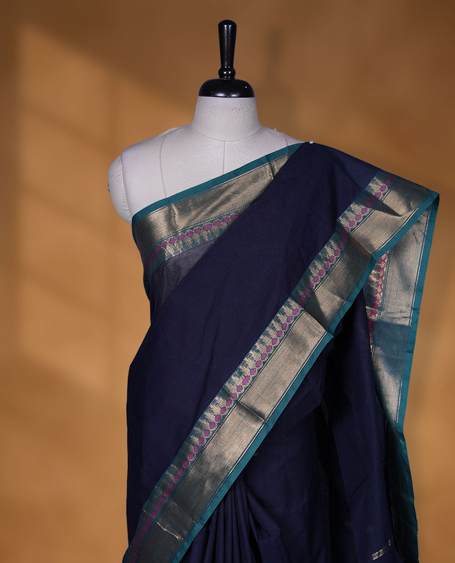 Dark Blue colour chettinad cotton saree featuring Elegant plain body, contrast green colour border with gold zari border, pallu and paired with matching blouse.