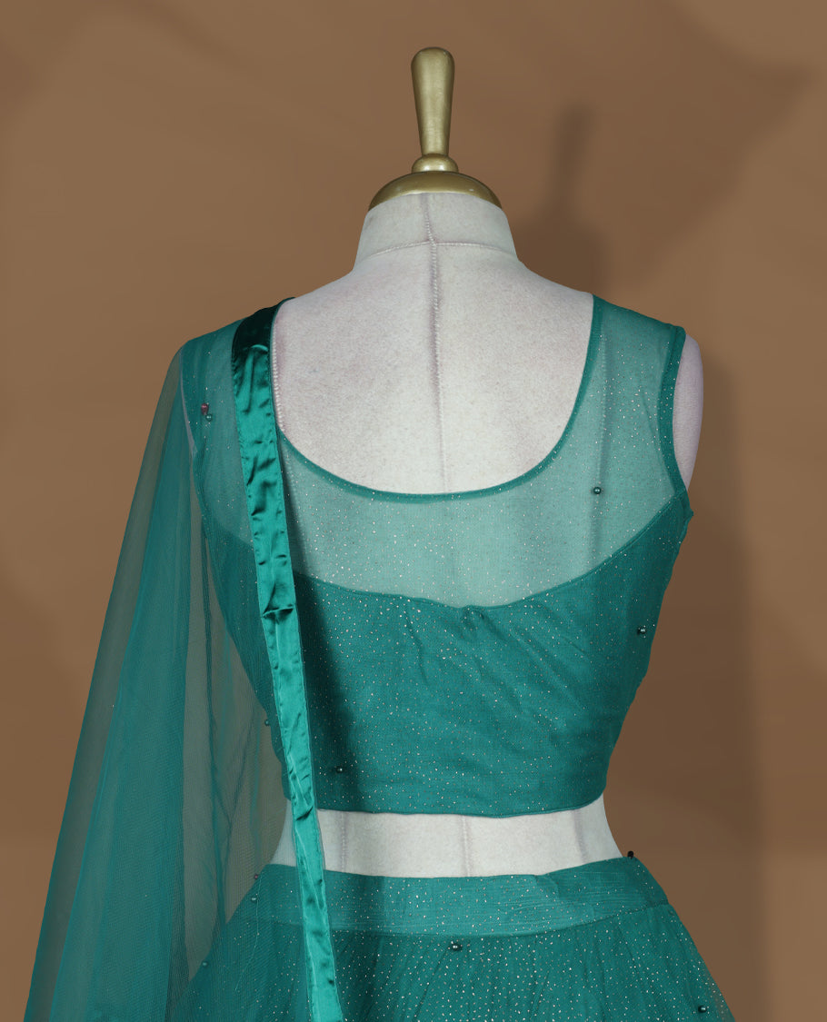 Teal green colour lehenga set with stitched sleeveless blouse featuring floral sequin embroidery on neckline and waist, paired with a matching shimmer layered flared lehenga and sheer dupatta