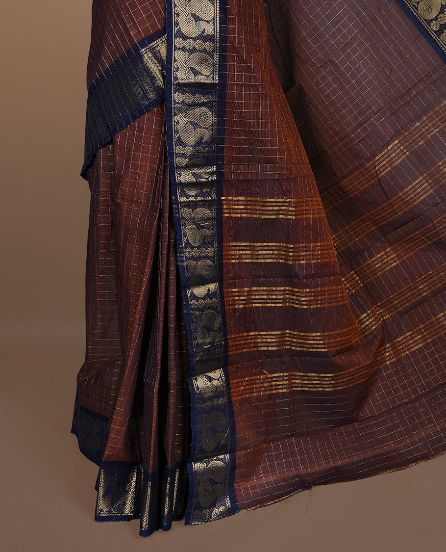Brown colour sungudi cotton saree featuring gold zari check pattern across body, contrast Dark blue colour with gold zari peacock and floral pattern on border, without blouse piece.