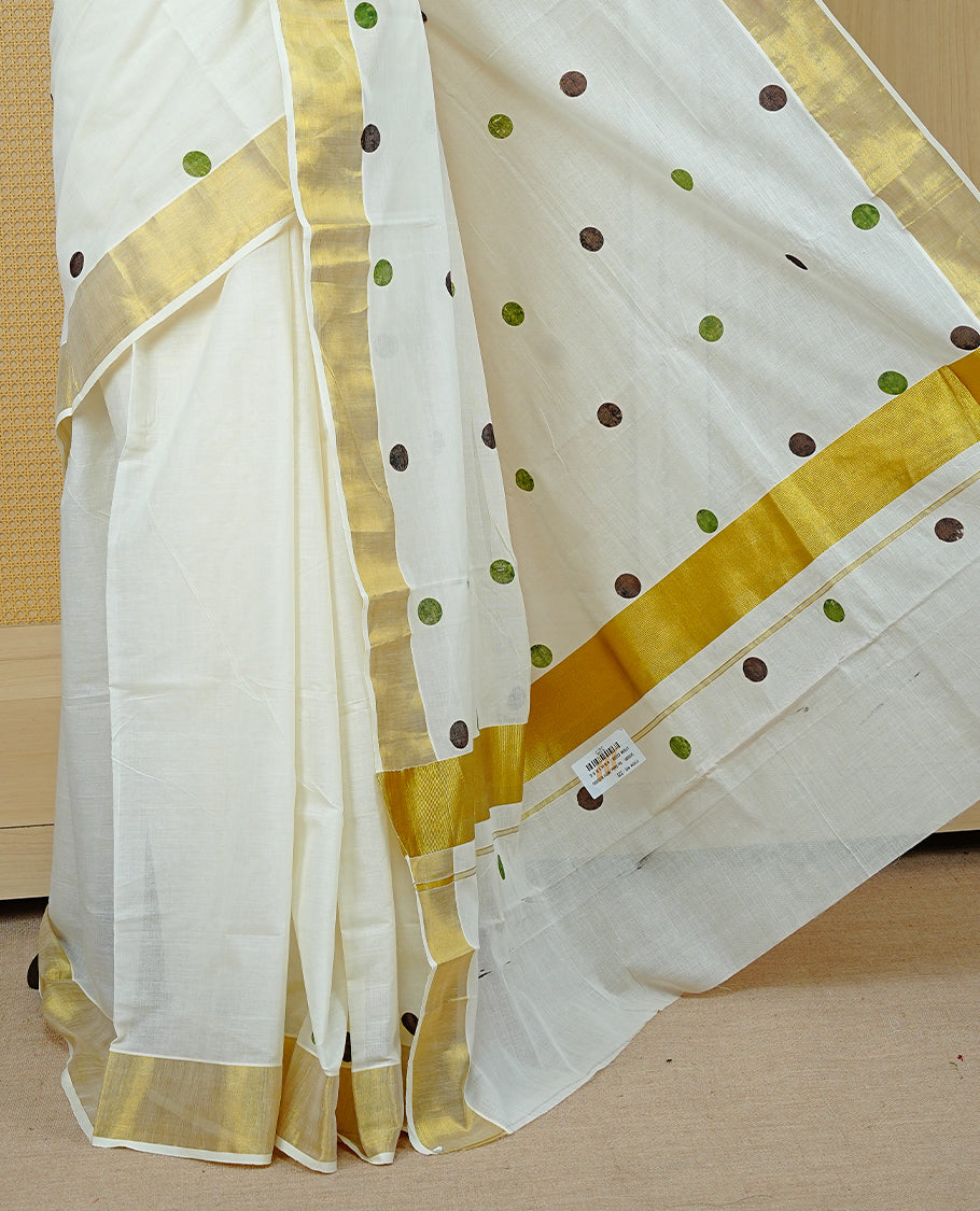 Cream Colour Kerala Saree Featuring Multicolour Dot Prints On The Body, Complemented By A Traditional Gold Zari Border, Paired With A Matching Blouse Piece.
