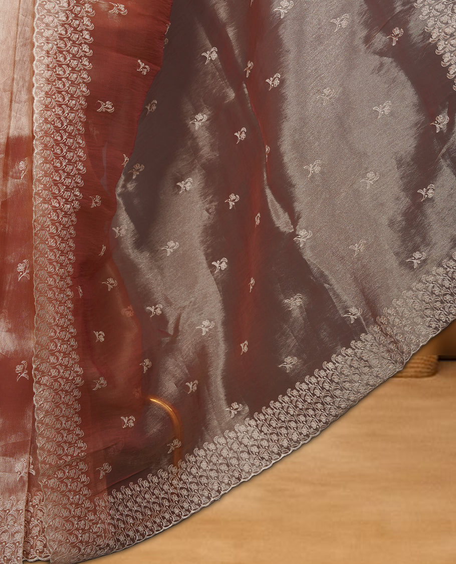 Pastel peach colour organza saree featuring white thread embroidery motifs on body and thread detailing on the border and paired matching blouse.