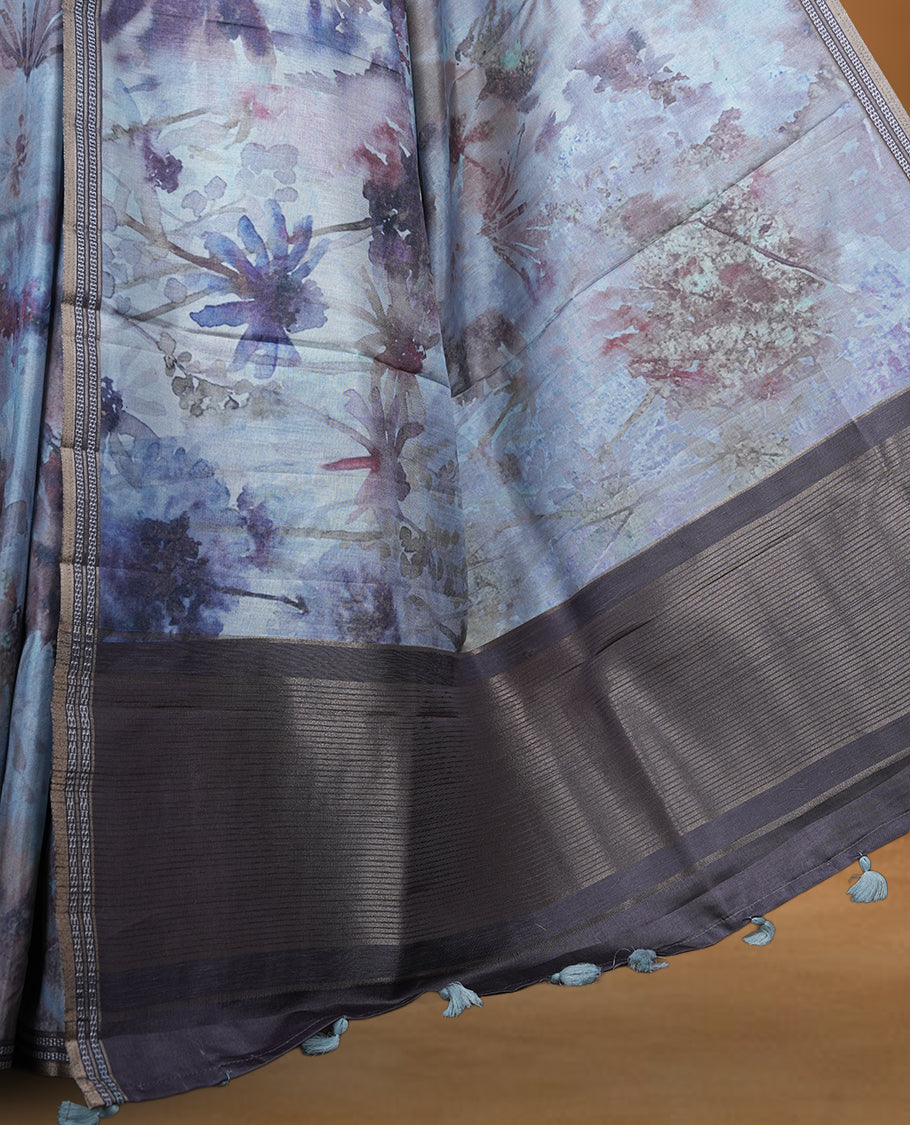 Smoky grey colour semi tussar silk saree featuring an abstract digital floral printed body, finished with a rich self border and tasselled pallu, paired with a matching blouse.