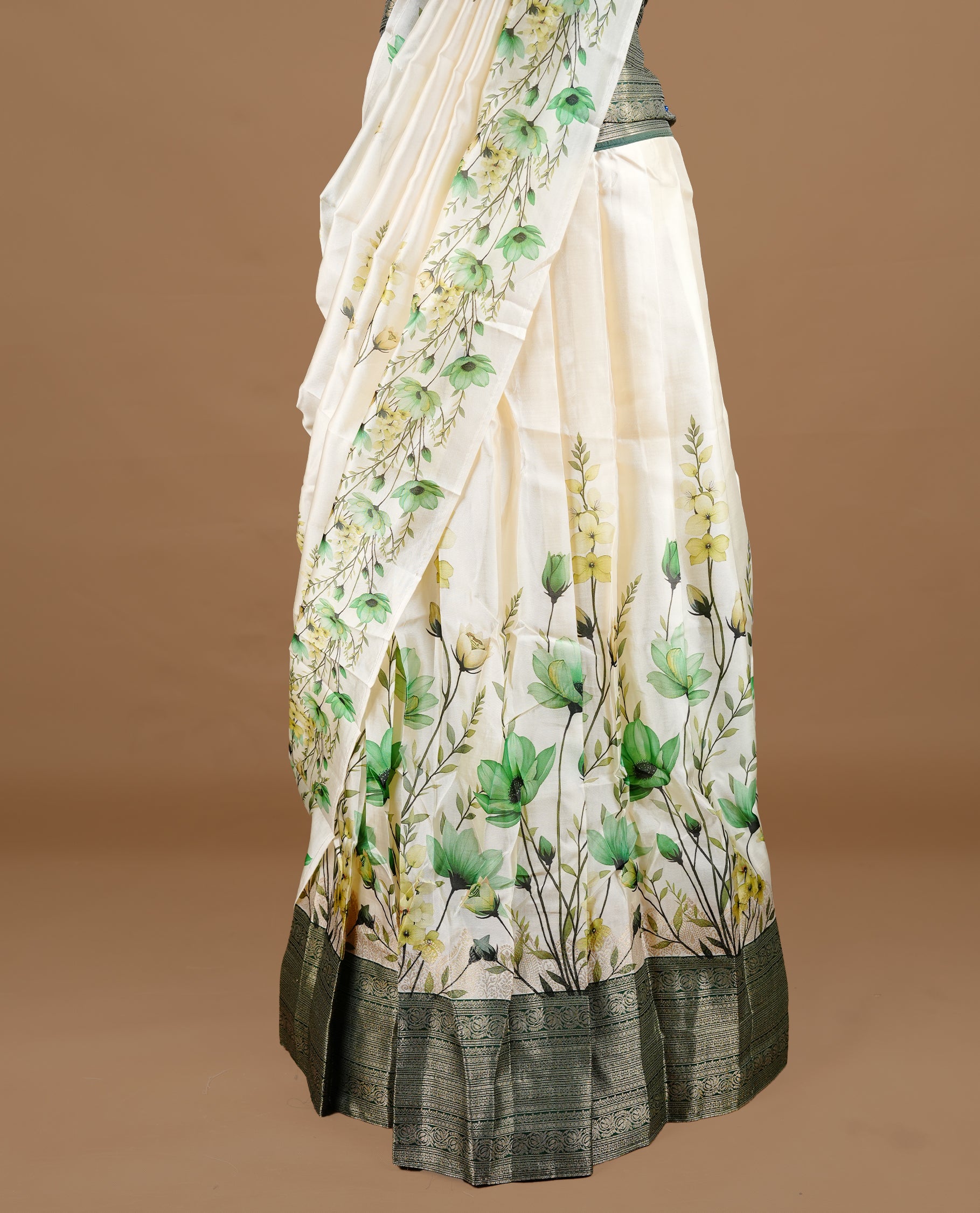 Off white colour semi stitched half saree featuring elegant Green colour floral prints, paired with a contrast green with traditonal zari border and matching printed dupatta ,paired with matching blouse piece.