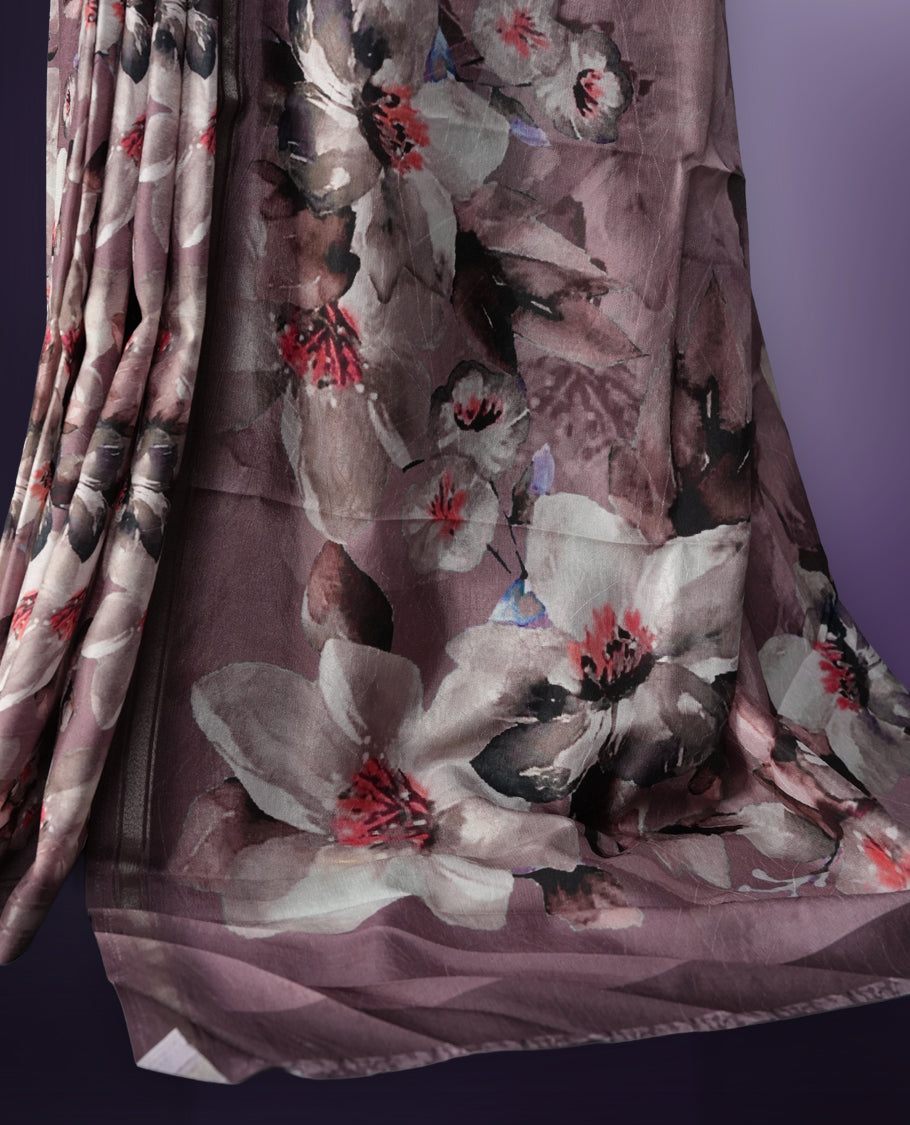 Mauve colour saree adorned with elegant floral prints on the body, enhanced with a subtle matching border, complemented by a beautifully printed pallu featuring blooming flowers, and paired with a matching blouse.