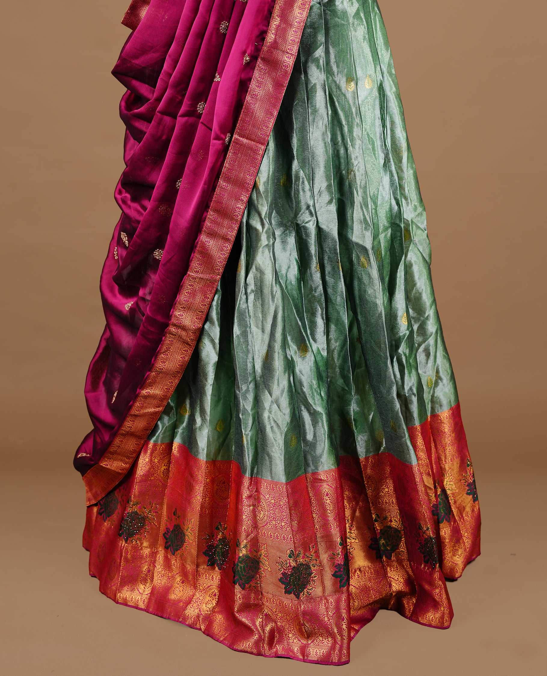 Green colour Half saree featuring green colour skirt with contrast magenta colour traditional border, paired with matching stitched blouse, matching dupatta.