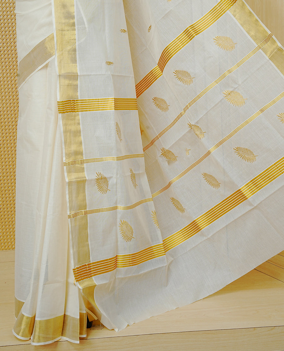 Cream Colour Cotton Kerala Saree Featuring Delicate Gold Zari Leaf Pattern Across The Body, Enhanced With A Traditional Gold Zari Border , A Gold Leaf Motifs Striped Gold Zari Pallu, Finished With A Matching Blouse Piece