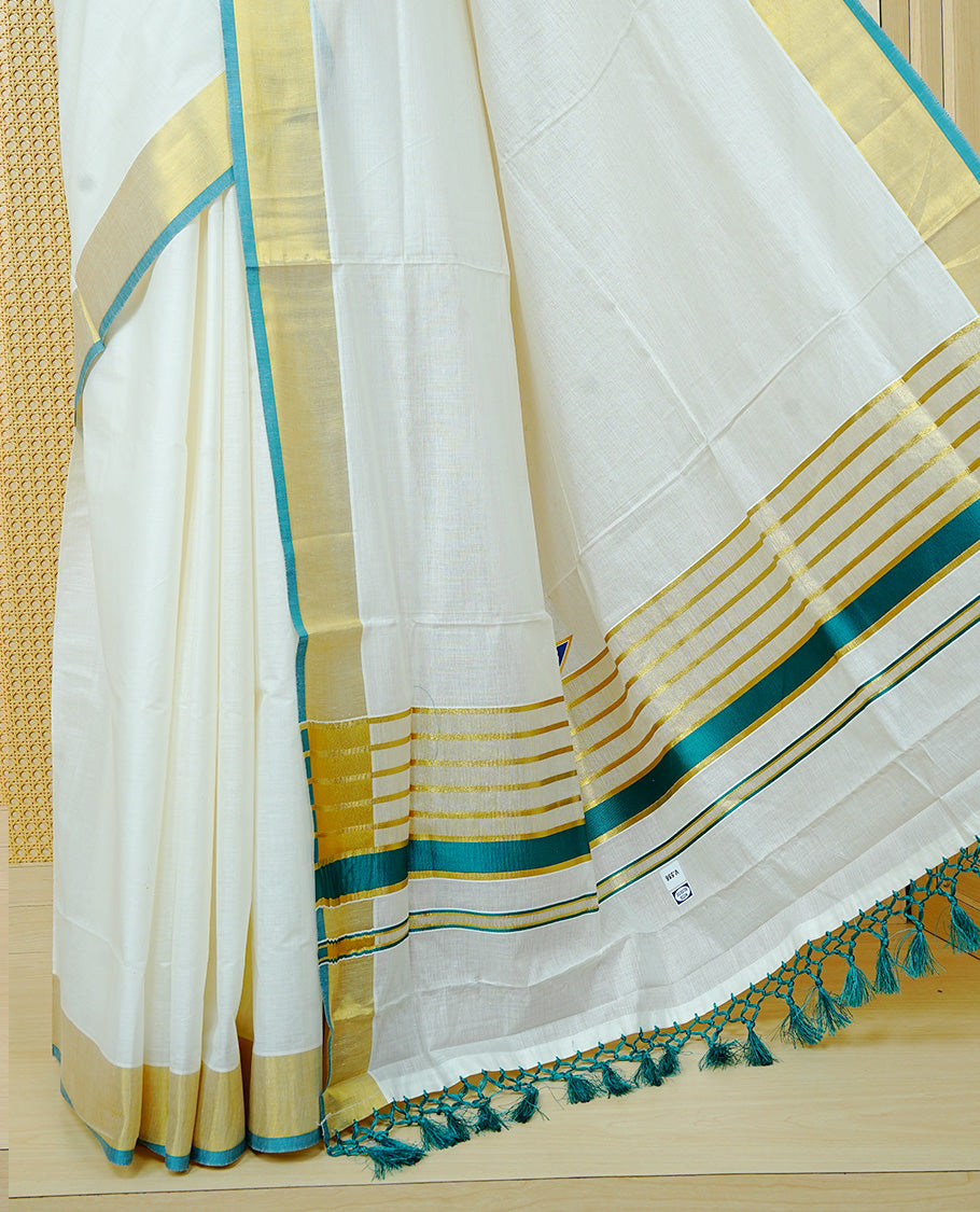 Cream colour Cotton kerala saree featuring Elegant Plain body, complemented by Gold zari with green colour border & Tassel on Pallu, paired with matching blouse piece.