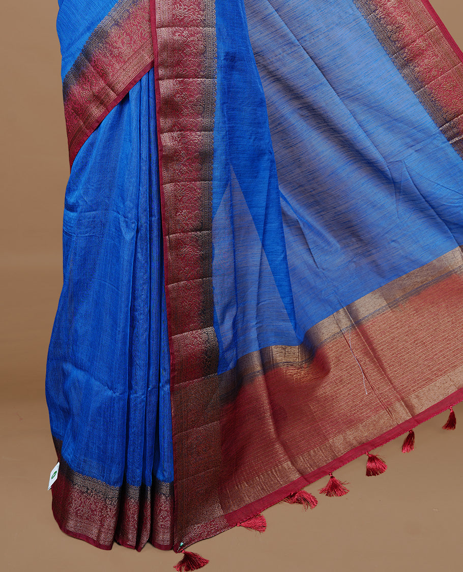 Blue colour Semi linen saree featuring Elegant plain body, complemented by contrast Maroon colour With Antique zari border, paired with matching blouse piece.