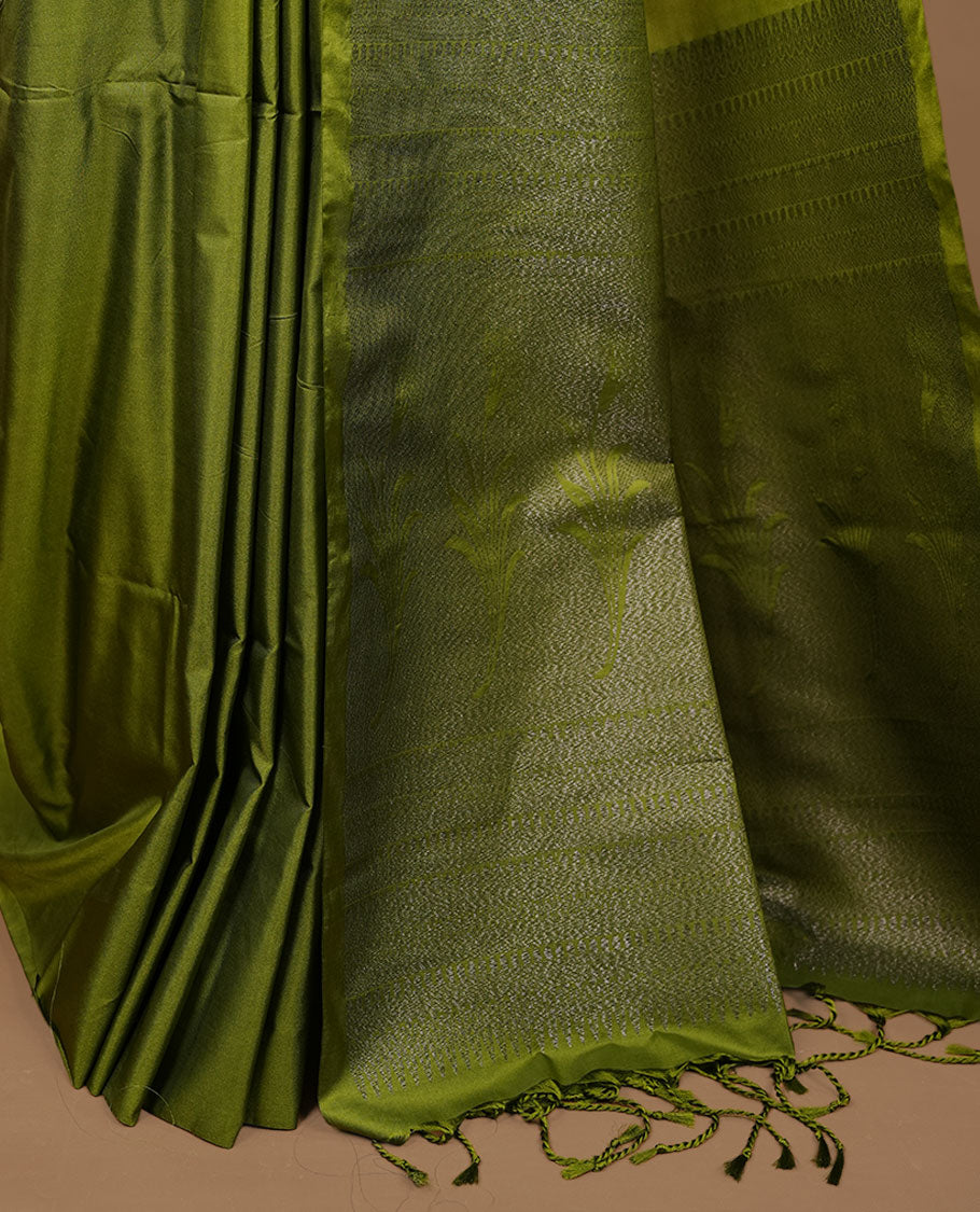 Olive soft silk saree features a sleek borderless design with intricate antique zari motifs, flowing into a seamless self colored pallu and a matching blouse piece.