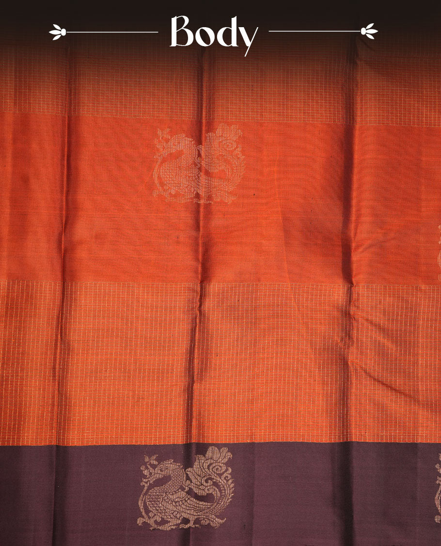 Brick red colour soft silk saree featuring zari check on body, complemented by contrast burgundy colour with peacock buttas border, paired with matching.