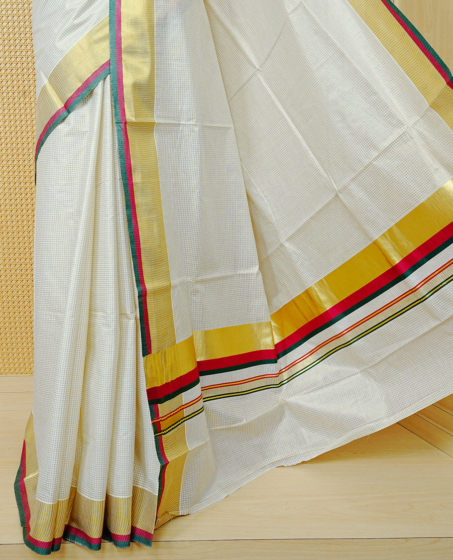 Cream colour cotton Kerala saree Featuring Gold zari Checks across the body, complemented by Classy gold zari with an Maroon & Green Border & pallu, paired with a matching blouse piece.