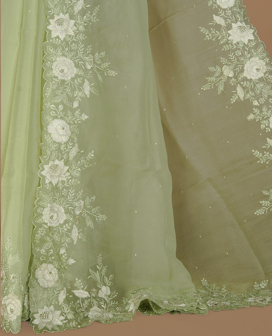 Pastel green colour organza saree featuring thread with cut beats & sequins floral pattern on body, highlighting scalp border, paired with matching blouse piece.