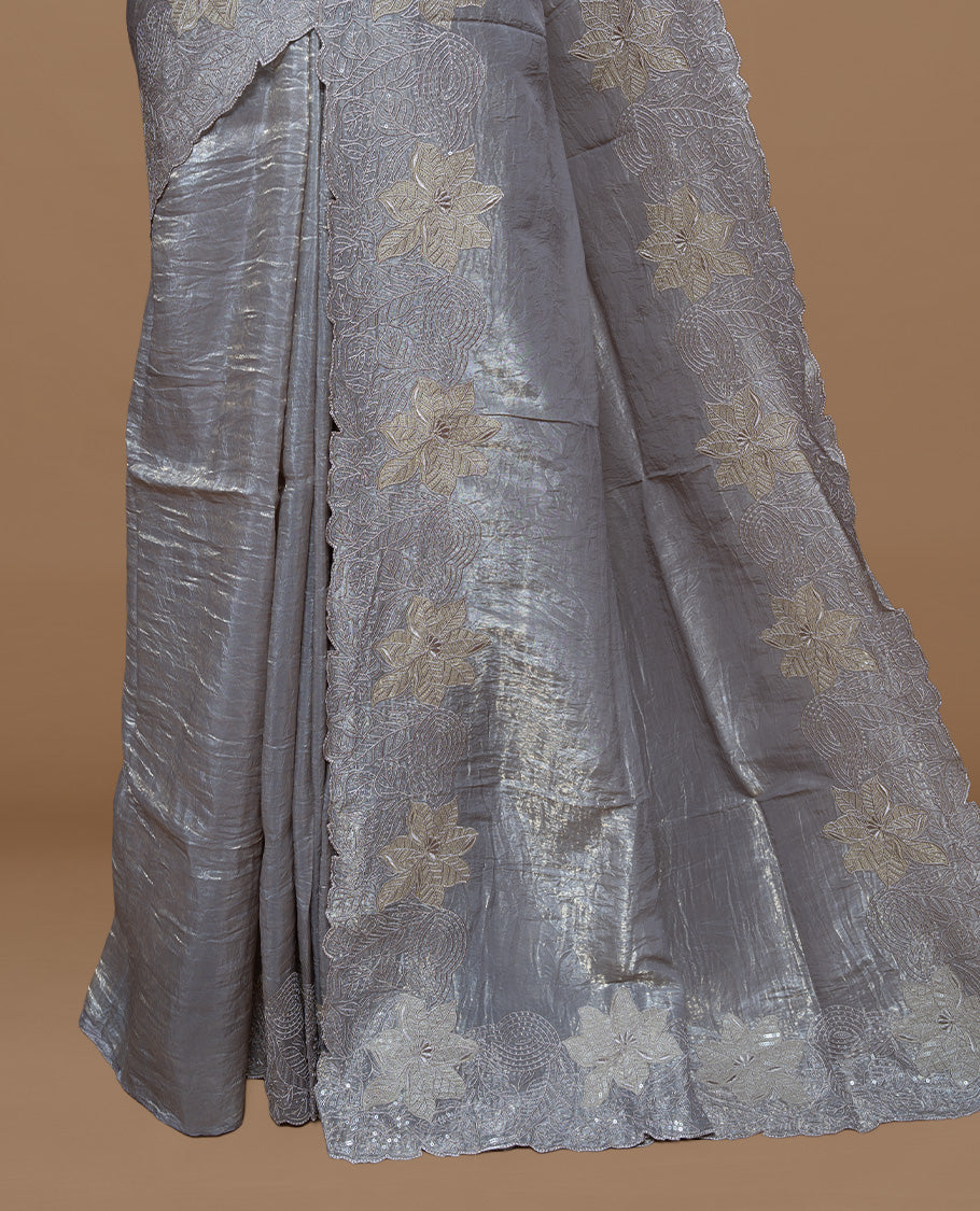 Grey colour Crush Organza Featuring Plain body, Enrich with Floral thread pattern with sequins & scalp border, paired with matching blouse piece.