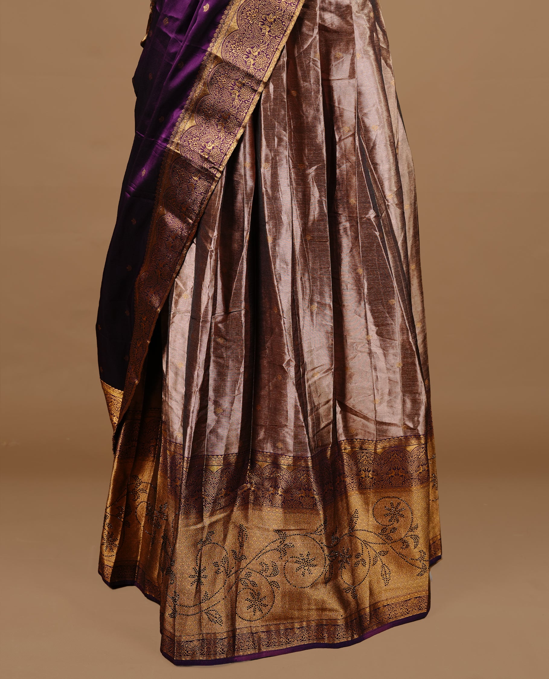 Purple colour Half saree featuring Purple colour skirt with contrast gold colour border with stone work, paired with contrast antique colour stitched blouse piece, with matching dupatta.