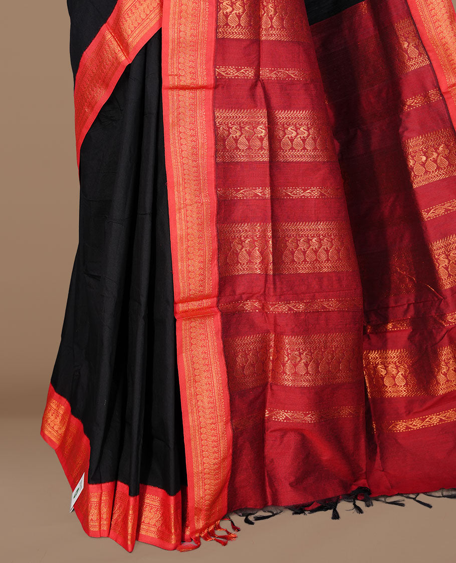 Black colour kalyani cotton saree featuring antique zari motifs on body, complemented by red colour with Antique zari border, paired with matching blouse piece.