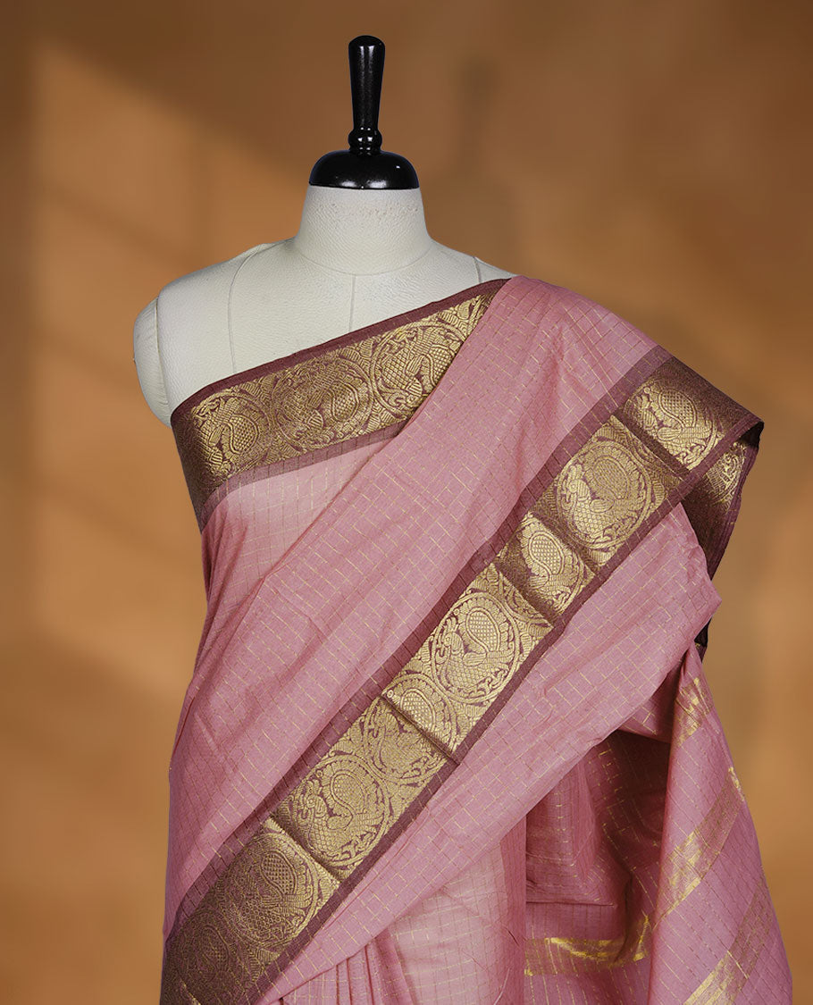 Light pink colour sungudi cotton saree featuring gold zari check pattern across body, contrast Mauve colour with gold zari peacock and floral pattern on border, without blouse piece.