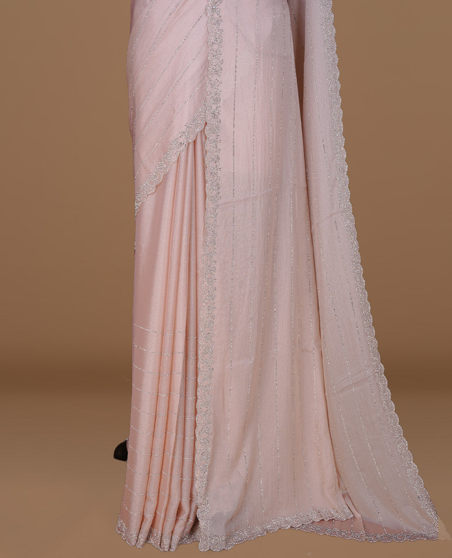 Light Peach colour designer saree featuring white stone stripes on body, highlighting white stone with scalp border, paired with matching blouse piece.