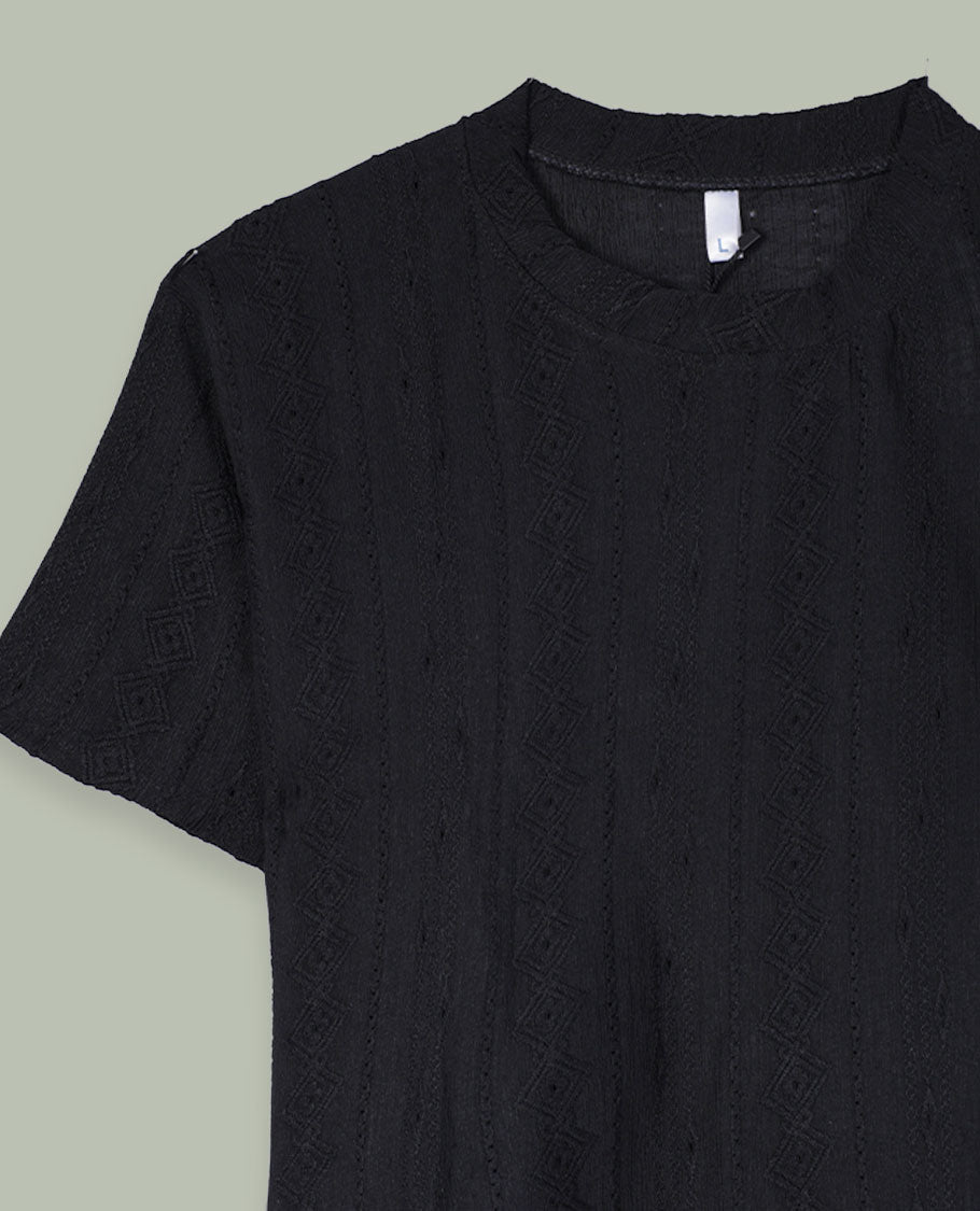 Black short-sleeve crop top with round neckline and subtle all-over self-textured geometric pattern.