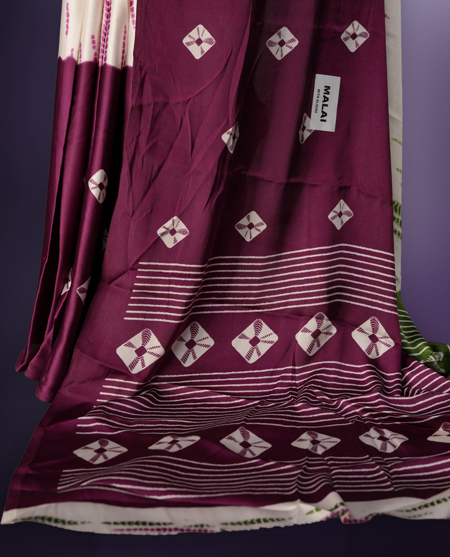 Rich green and purple saree adorned with small woven motifs on the body, enhanced by a contrast border, complemented with a traditional patterned pallu, and paired with a matching blouse.