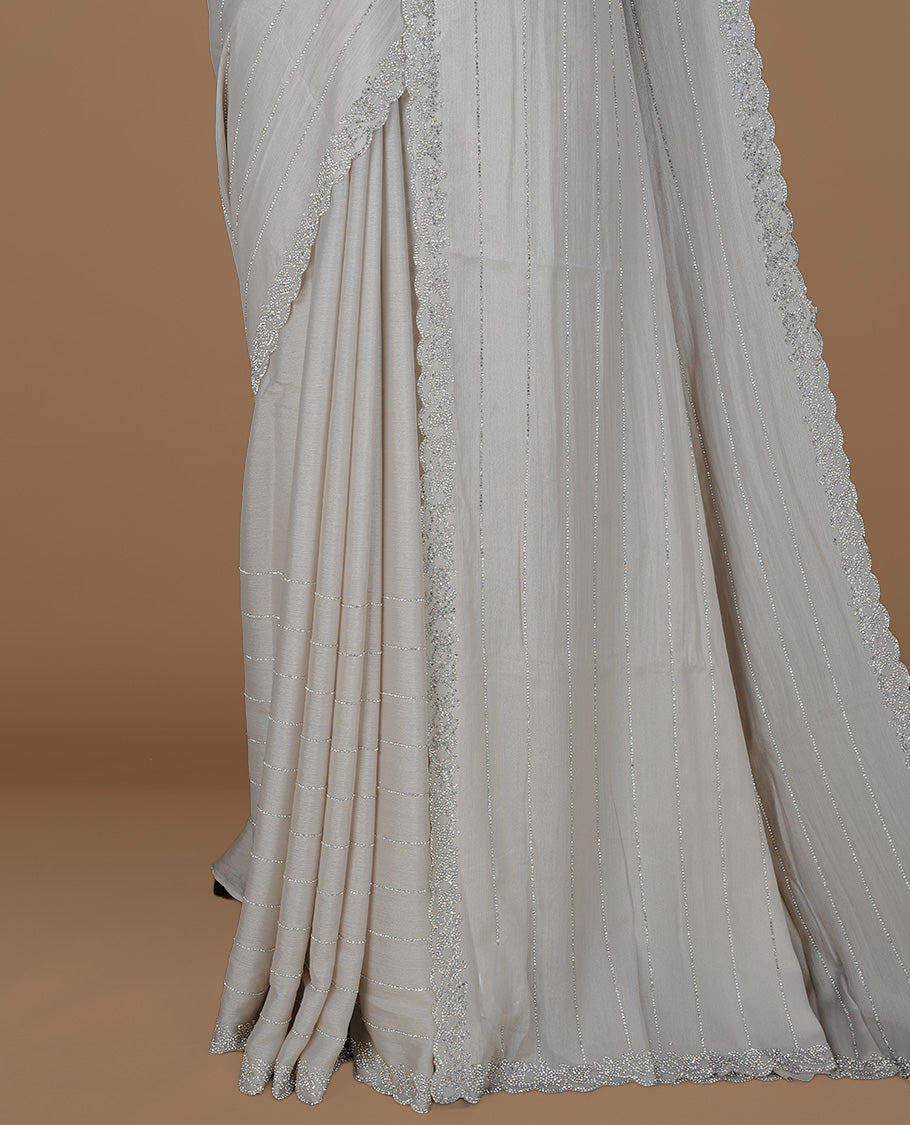 Grey colour designer saree featuring white stone stripes on body, highlighting white stone with scalp border, paired with matching blouse piece.