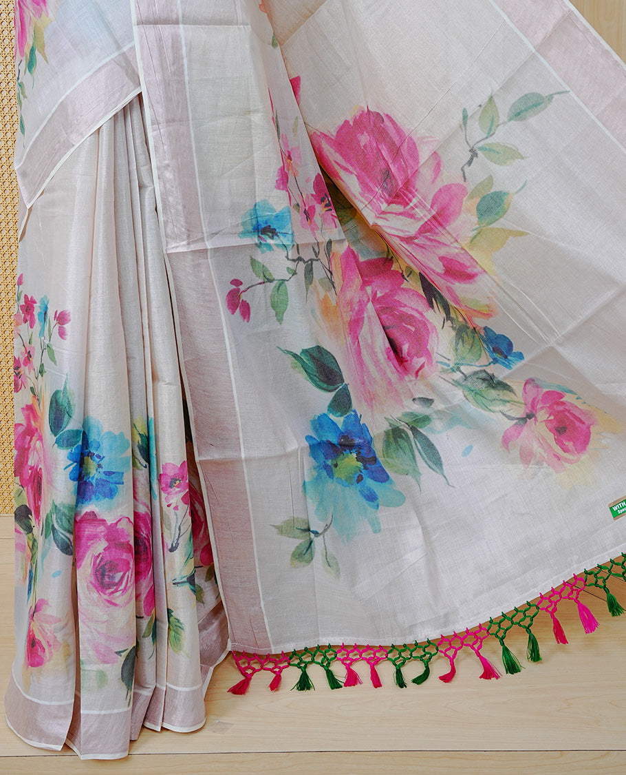 Cream Colour Tissue Kerala Saree Featuring Digital Floral Prints Across The Body, Enhanced With A Rose Gold Zari Border, Finished With Pink & Green Tassels And A Matching Blouse Piece