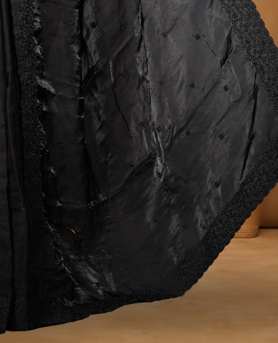Black colour organza saree featuring self colour thread embroidery work on body and border, paired with matching blouse piece.