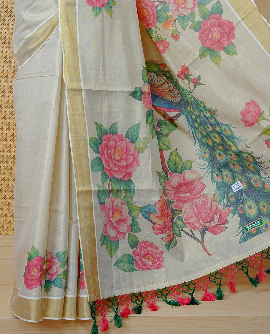 Cream Colour Tissue Kerala Saree Featuring A Digital Peacock Floral Printed Body, Highlighted With Classy Gold Zari Border Green & Coral Pink Tassel At Pallu, Paired With A Matching Blouse Piece.