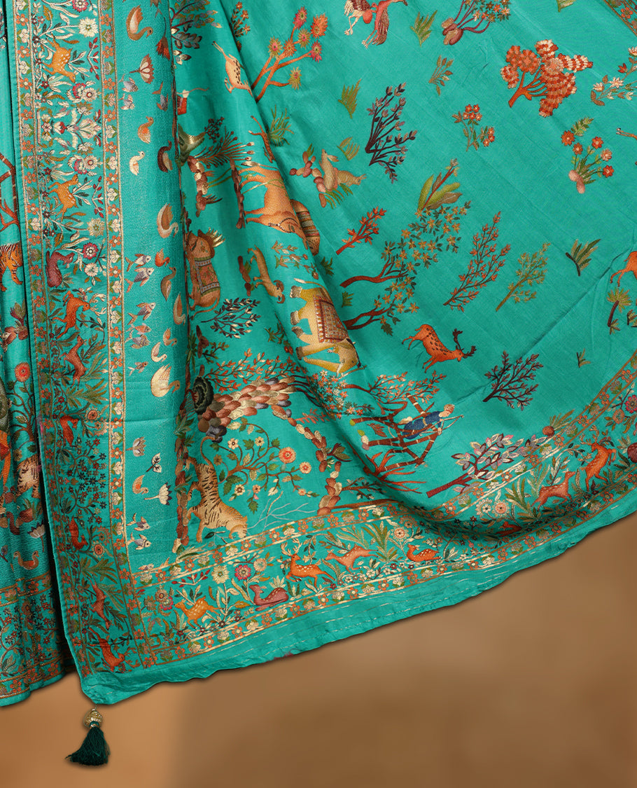 Turquoise sea green colour Pashmina silk saree lavishly adorned with all‑over woven wildlife and forest motifs, framed by an intricately detailed animal & floral zari border and grand storytelling pallu, paired with a matching woven border blouse piece.