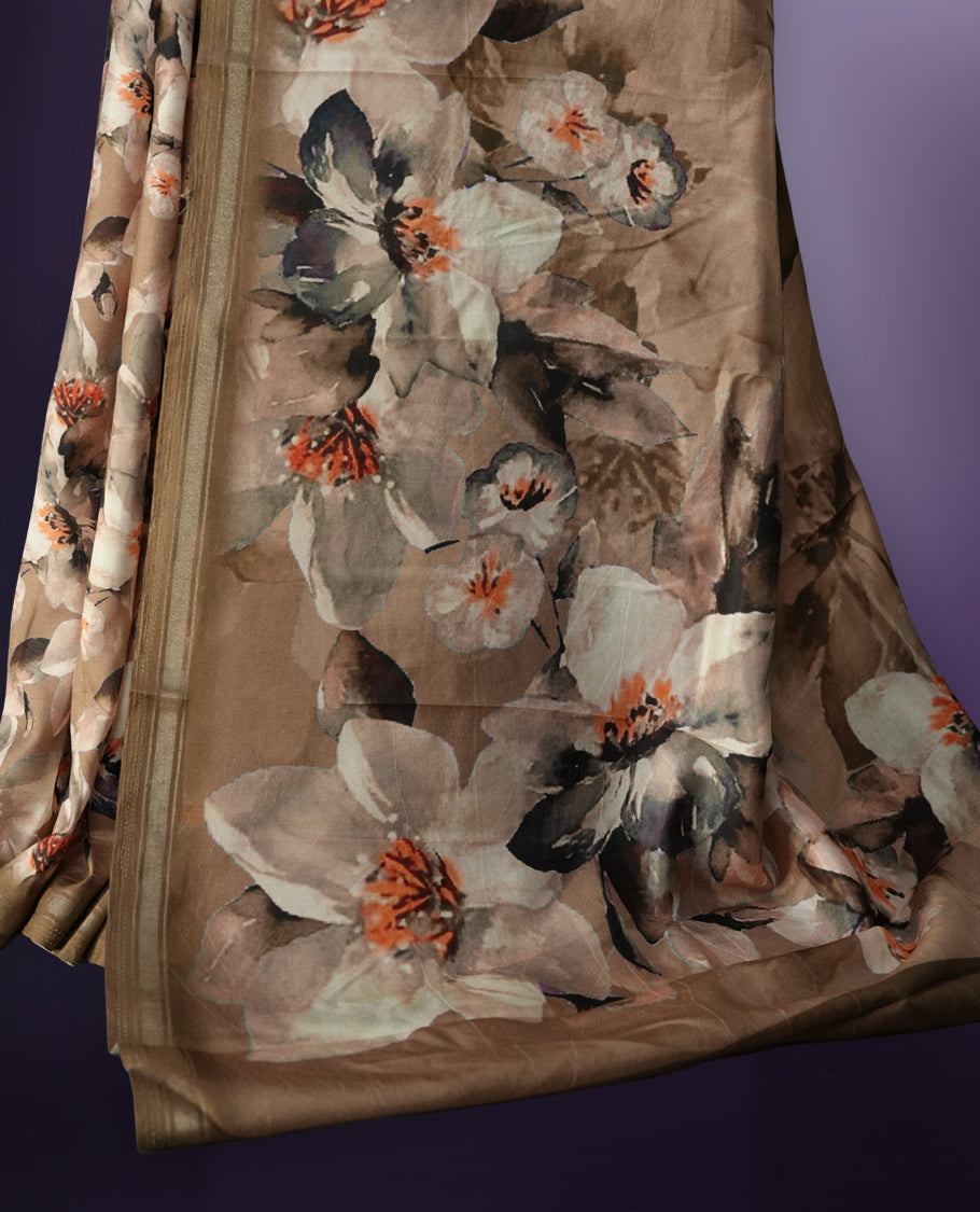 Pastel brown colour saree adorned with elegant floral prints on the body, enhanced with a subtle matching border, complemented by a beautifully printed pallu featuring blooming flowers, and paired with a matching blouse.