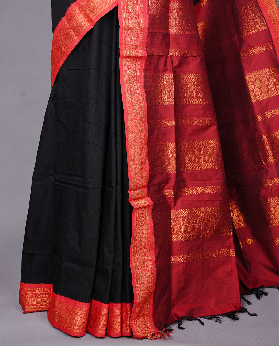 Black colour kalyani cotton saree featuring antique zari motifs on body, complemented by red colour with Antique zari border, paired with matching blouse piece.