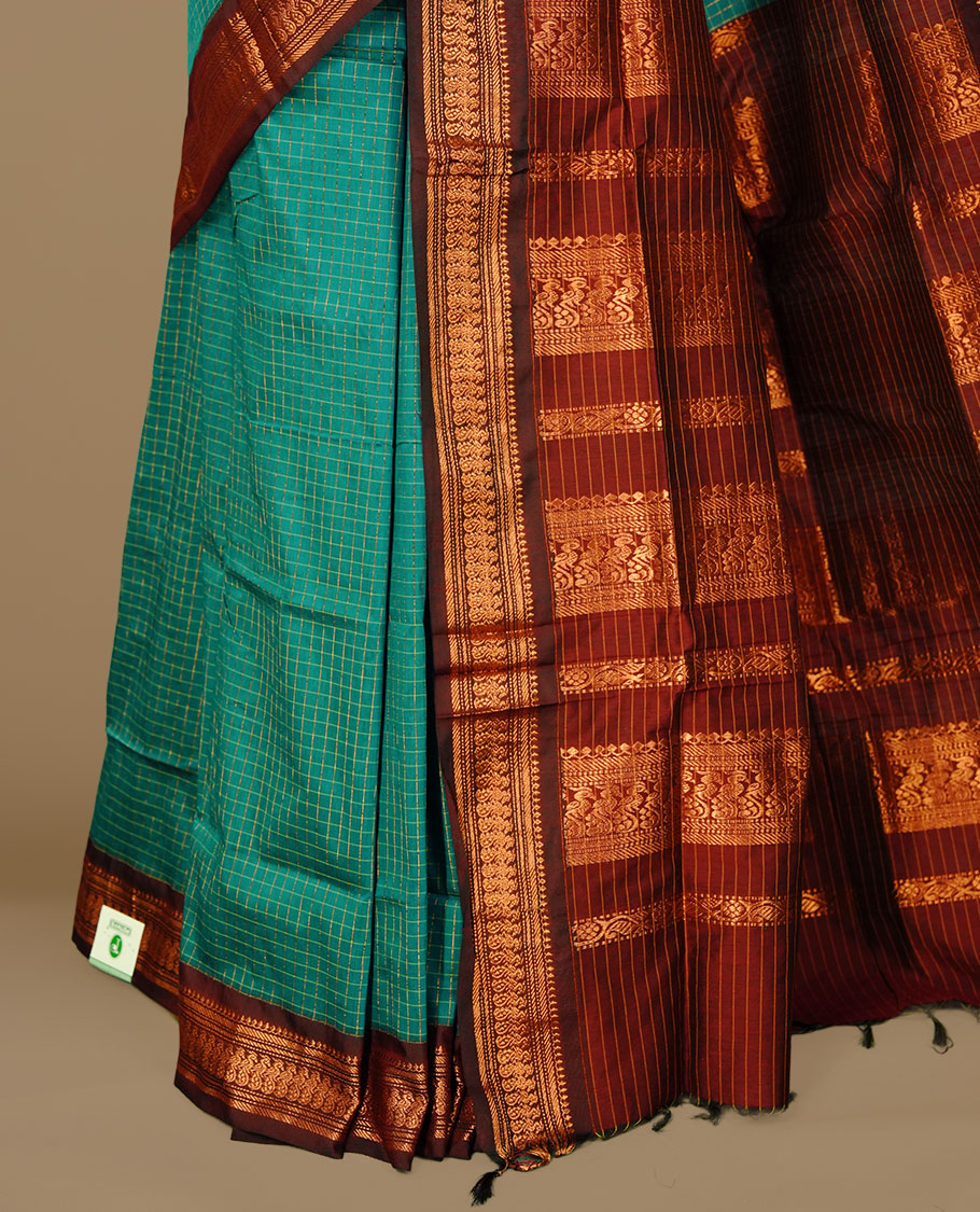 Teal green colour kalyani cotton saree featuring gold zari check pattern on body, complemented by Maroon colour with Antique zari border, paired with matching blouse piece.
