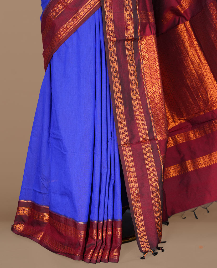 Navy blue colour kalyani cotton saree featuring gold zari motifs on body, complemented by contrast maroon color with copper zari pattern border , paired with matching blouse piece.