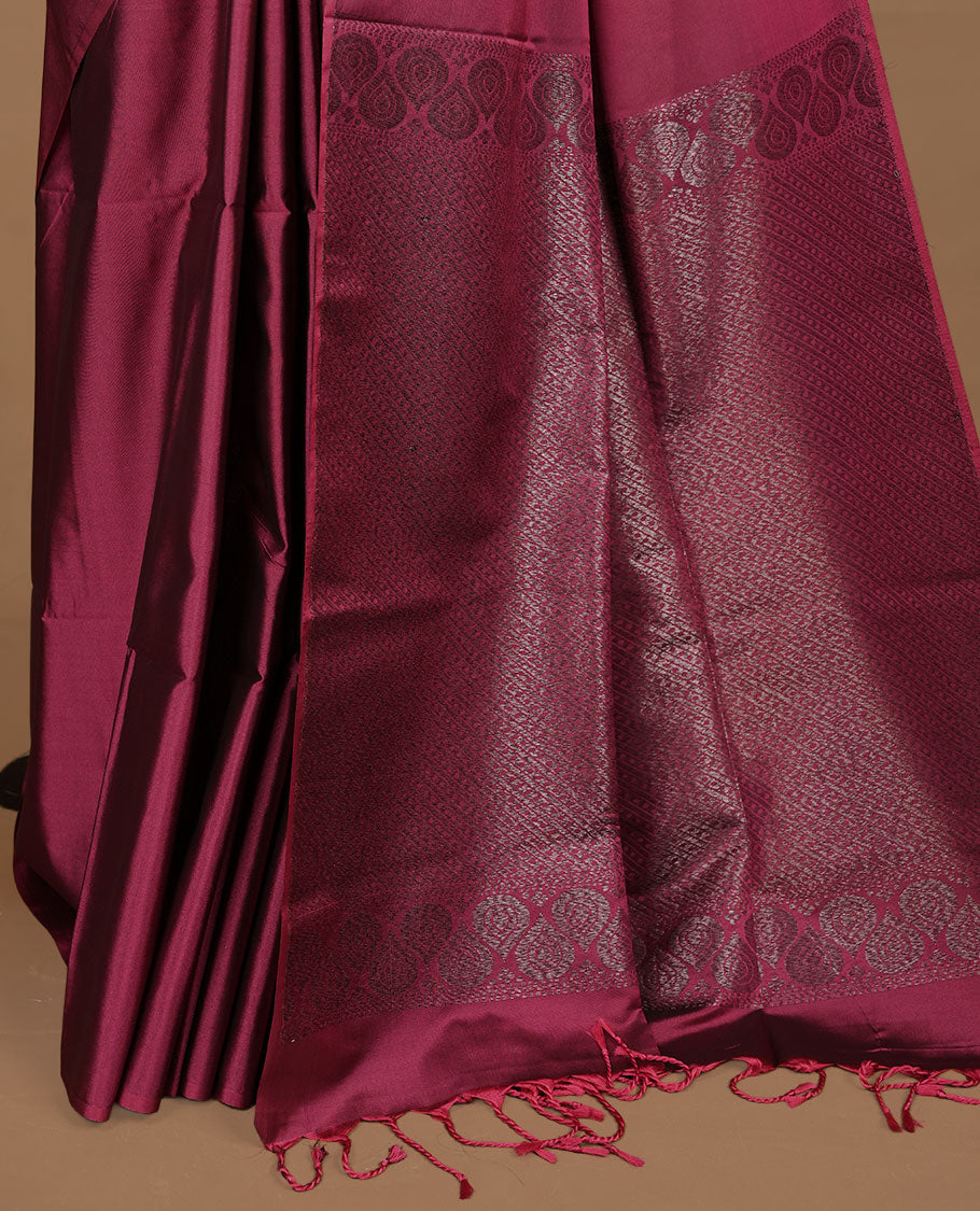 Dusty magenta soft silk saree features a sleek borderless design with intricate antique zari motifs, flowing into a seamless self colored pallu and a matching blouse piece.