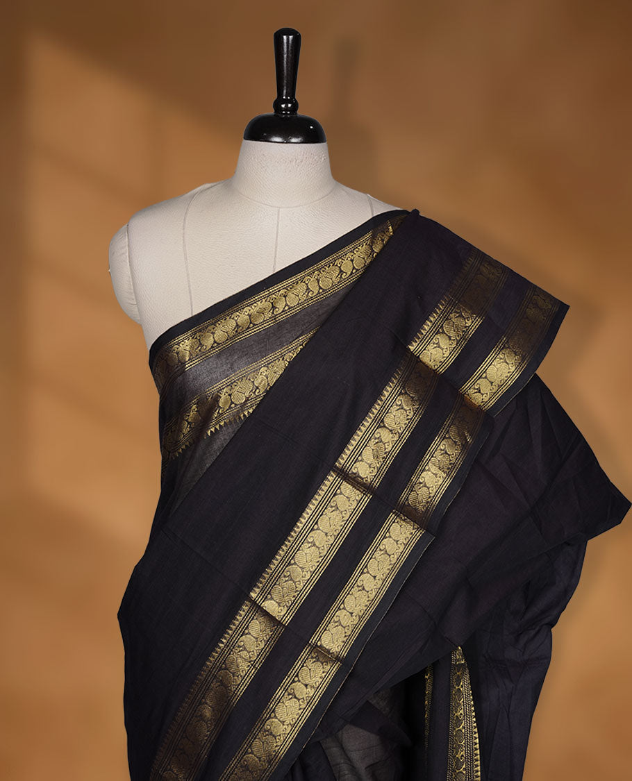 Dark Navy Blue colour chettinad cotton saree featuring plain body, with matching traditional gold zari border paired with matching blouse.