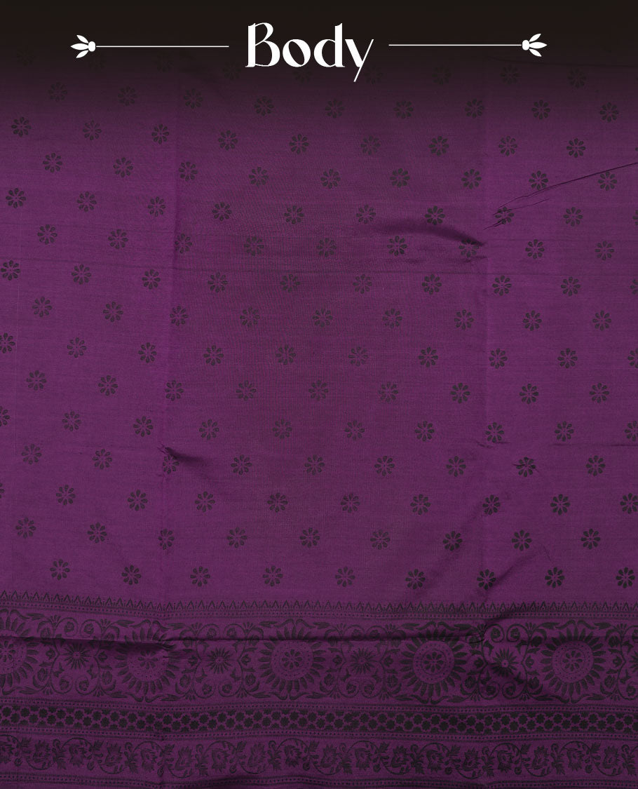 Grape Purple colour poly cotton saree with black floral butti motifs on the body, paired with a matching pallu featuring black ornate floral jaal and stripes on the border, and a coordinated all‑over black paisley printed blouse piece.