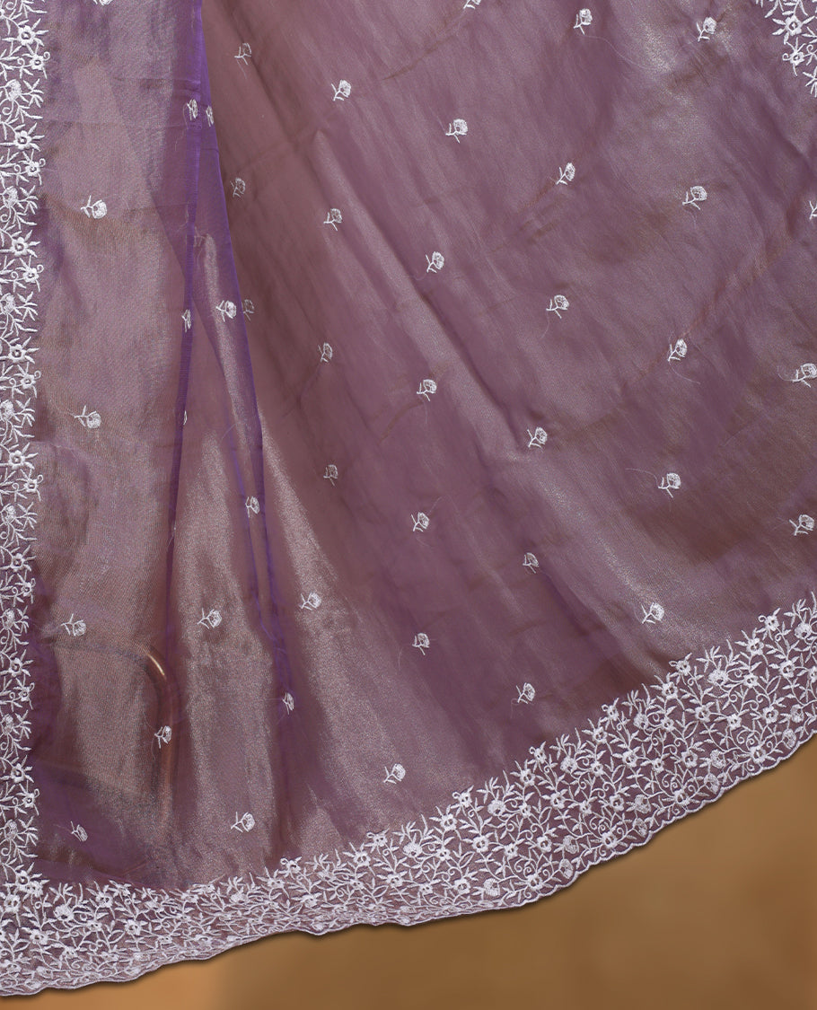 Light purple colour net organza designer saree featuring a subtle self patterned body and an intricately scalloped floral thread embroidered border all around, complemented by a coordinating embroidered pallu and paired with a matching blouse.
