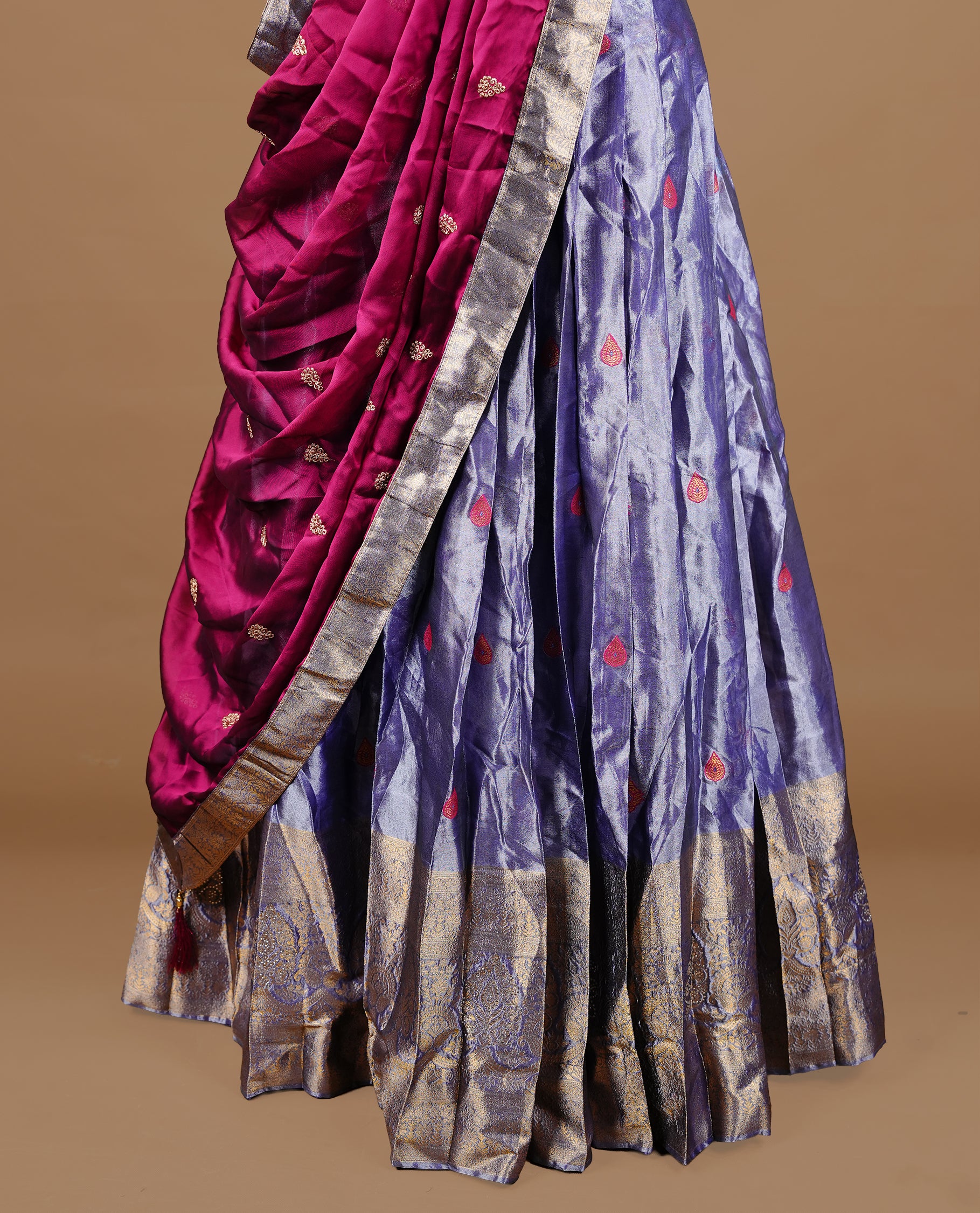 Lavender colour featuring lavender colour skirt highlighting gold zari motifs & border, contrast maroon dupatta, with matching stitched blouse.
