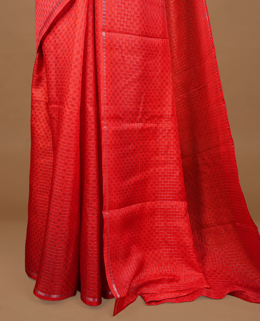 Red colour Semi Tussar saree featuring an elegant zari fancy check pattern on the body, highlighted with a small border for a refined look. Comes without a blouse piece.