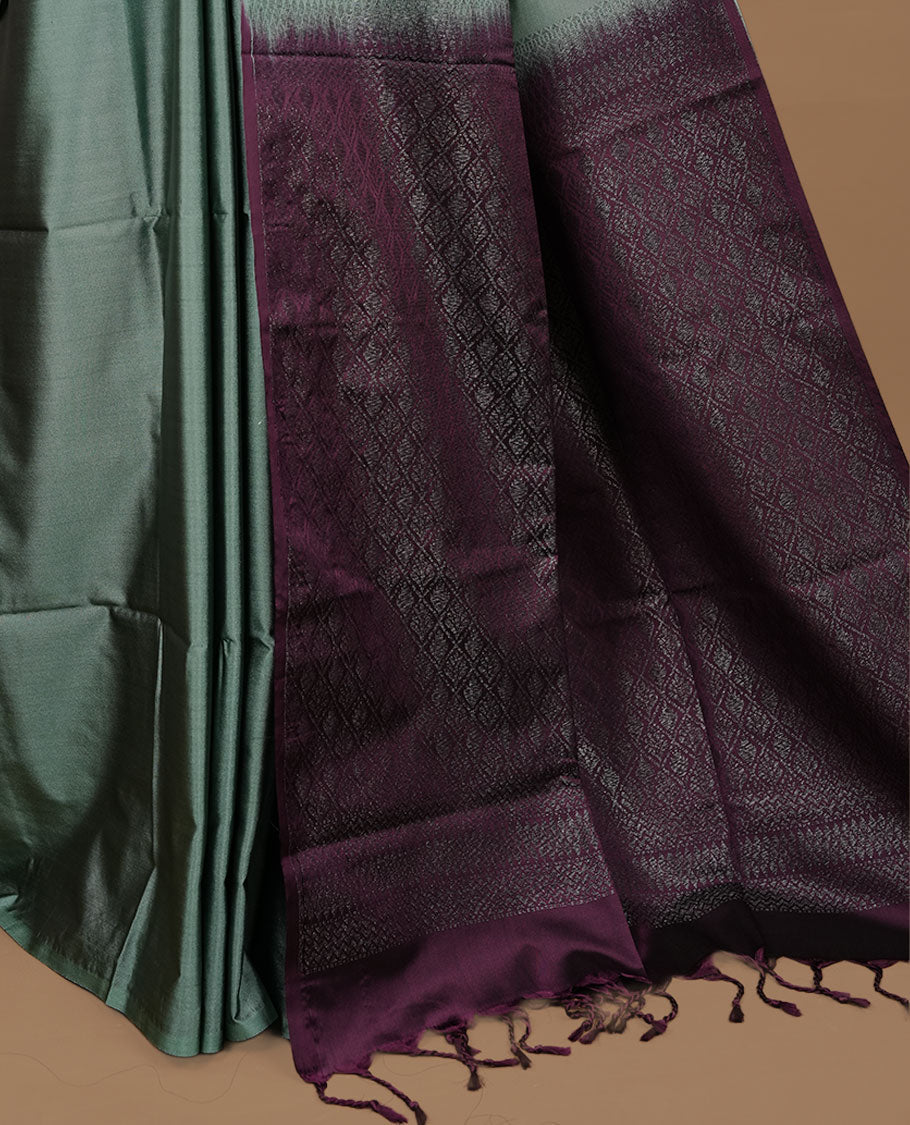 Pastel green colour soft silk saree features a sleek borderless design with intricate antique zari motifs, flowing into a striking contrast purple pallu and a matching blouse piece.