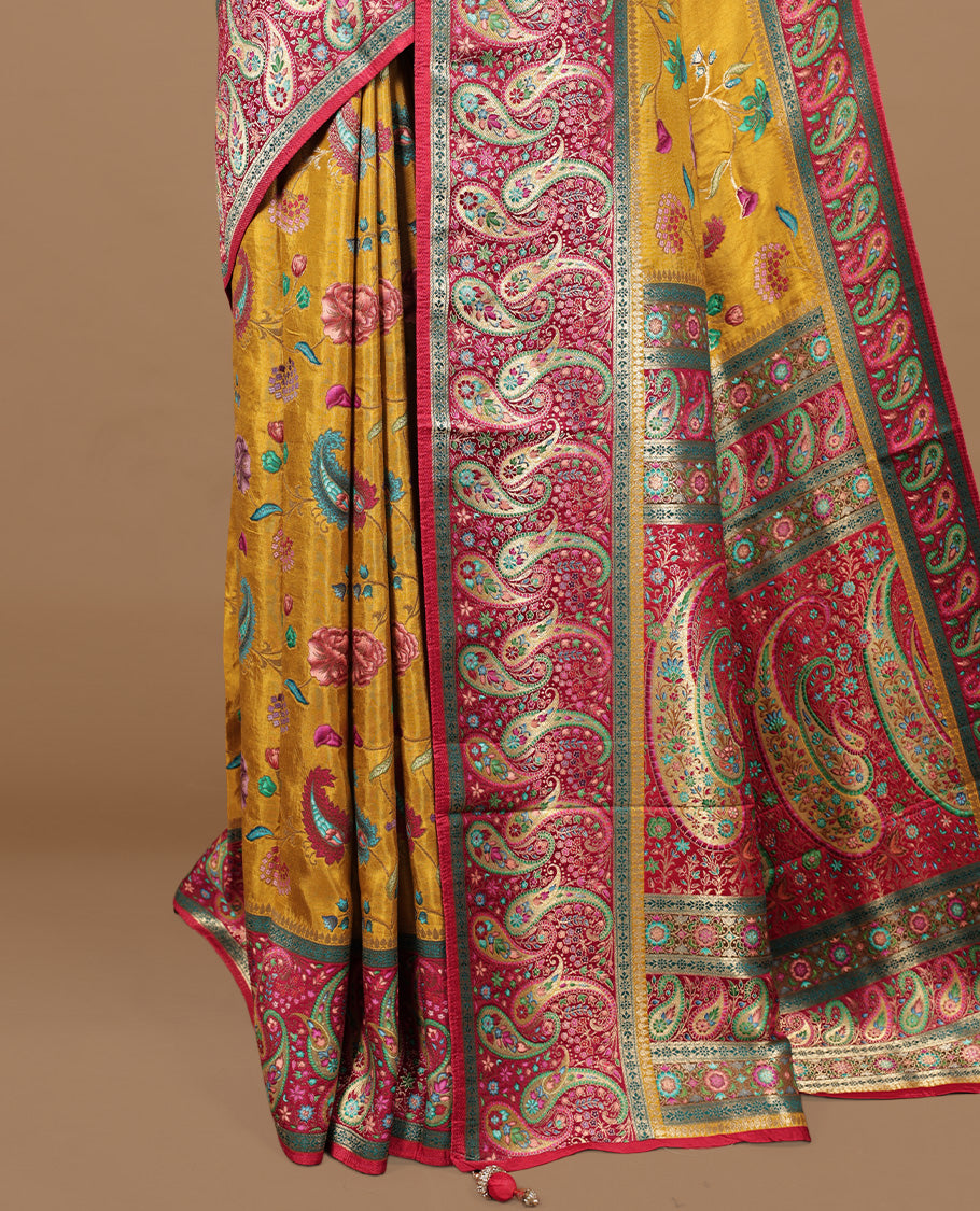 Mustard yellow colour Pashmina silk saree features an all over floral body, a contrast crimson red paisley border and pallu, and a matching unstitched blouse.