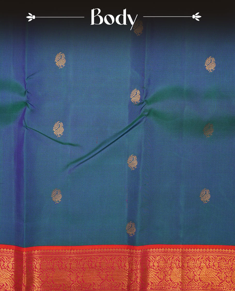 Peacock Blue colour pure traditional Kancheepuram silk saree adorned with gold zari peacock motifs across the body, featuring elegant contrast Pink traditional borders, beautifully paired with a matching blouse piece.