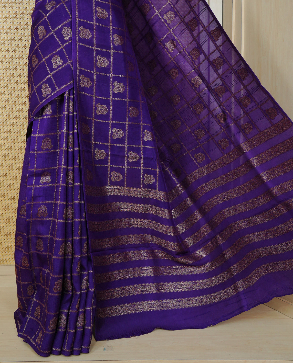 Violet colour semi banaras tussar georgette saree featuring gold zari check with motifs on body, no specific border and paired with matching blouse piece.